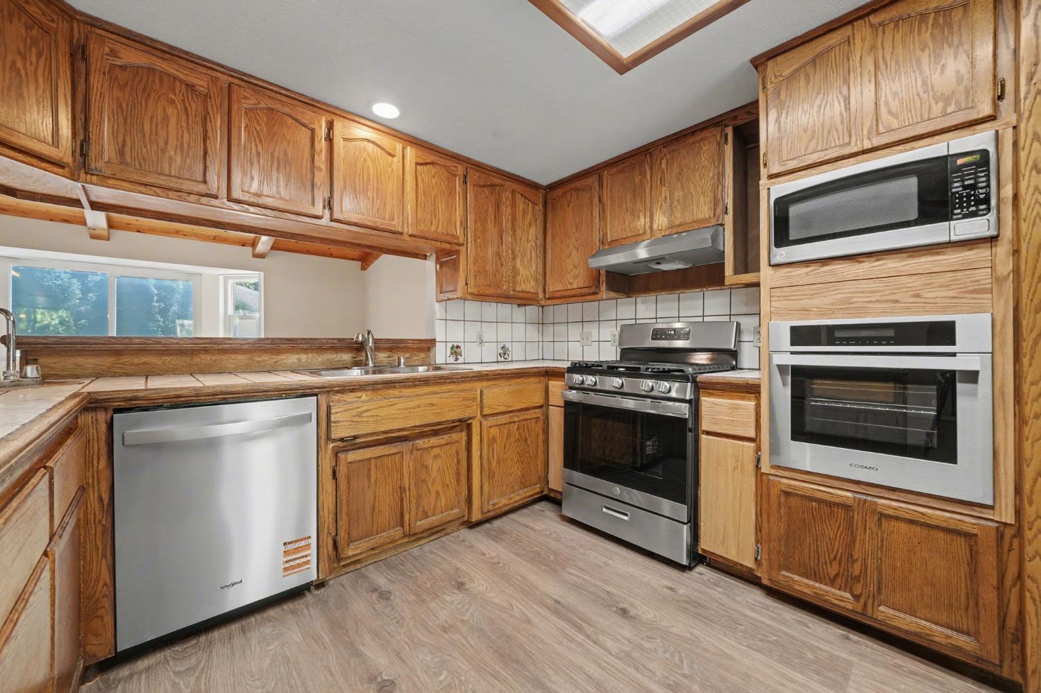 23781 Golden Ridge Drive Volcano, CA 95689 - Photo 20 of 50 a kitchen with granite countertop wooden cabinets stainless steel appliances and a sink