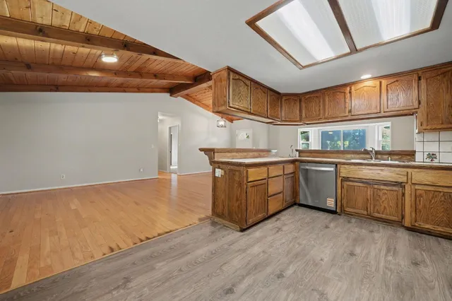 a kitchen with a sink a window stainless steel appliances and cabinets