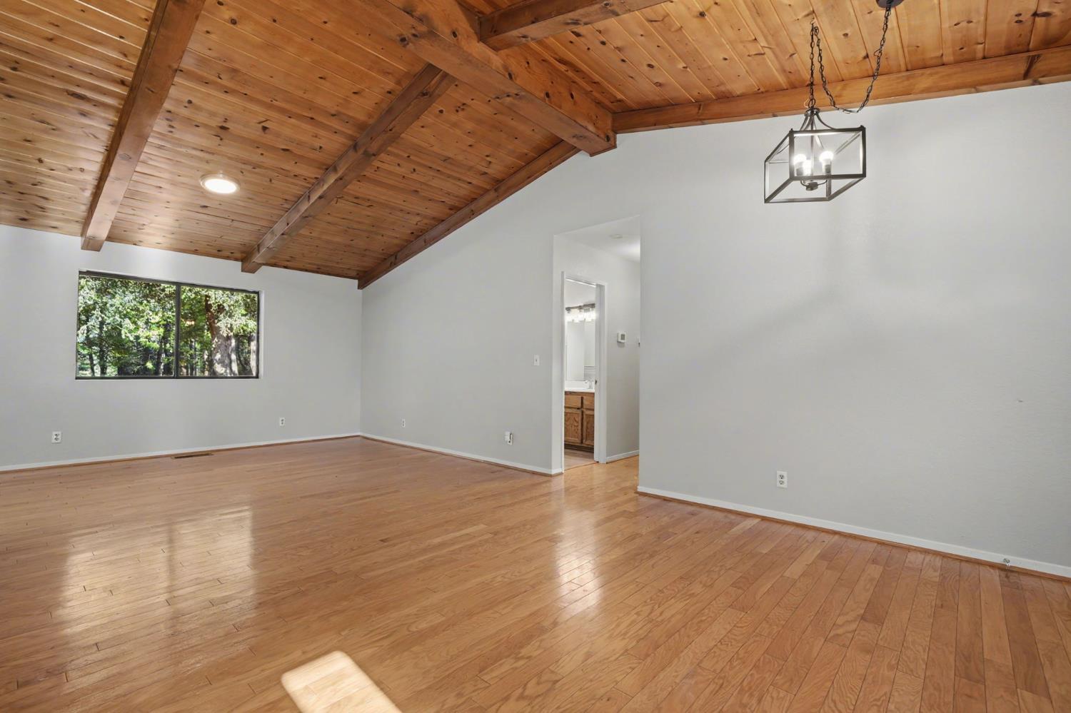 23781 Golden Ridge Drive Volcano, CA 95689 - Photo 7 of 50 an empty room with wooden floor and windows