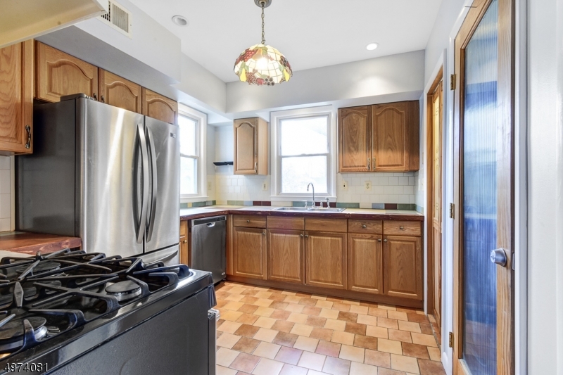 558 Summit Avenue, Unit 1 Westfield, NJ 07090 - Photo 7 of 13 a kitchen with stainless steel appliances granite countertop a sink stove and refrigerator