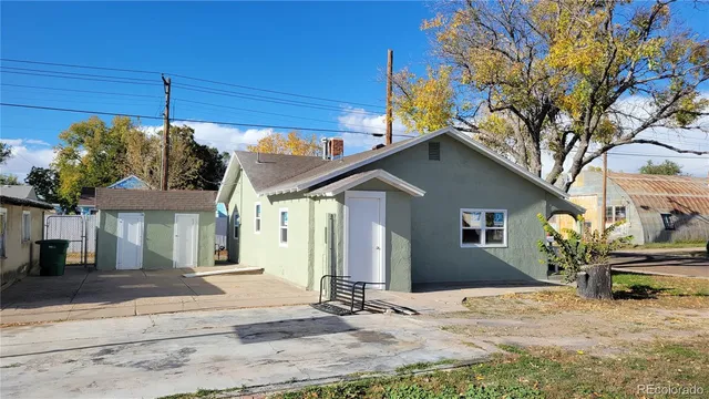 a backyard of a house with table and chairs