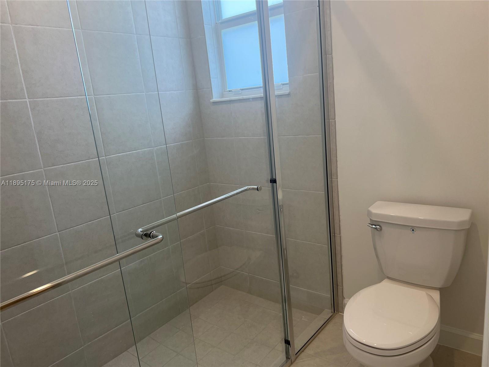 16960 Southwest 288th Terrace, Unit 16960 Homestead, FL 33033 - Photo 12 of 33 a white toilet sitting next to a shower