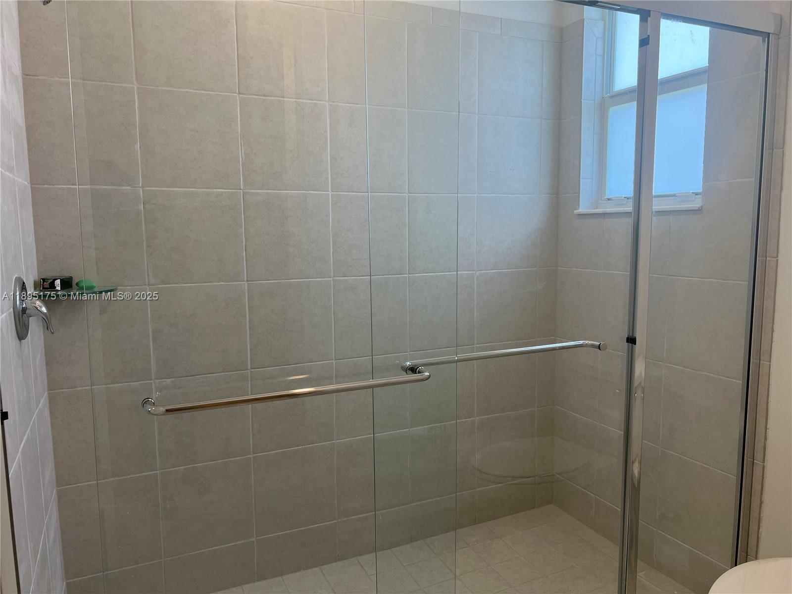 16960 Southwest 288th Terrace, Unit 16960 Homestead, FL 33033 - Photo 16 of 33 a bathroom with a glass door shower