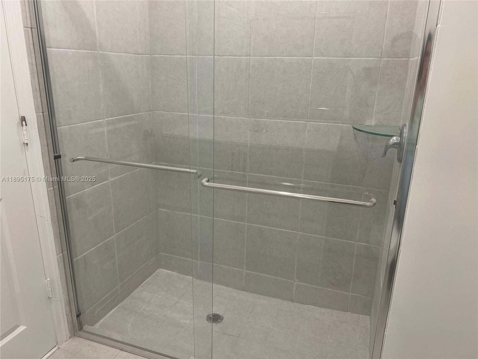 16960 Southwest 288th Terrace, Unit 16960 Homestead, FL 33033 - Photo 19 of 33 a bathroom with a glass shower door
