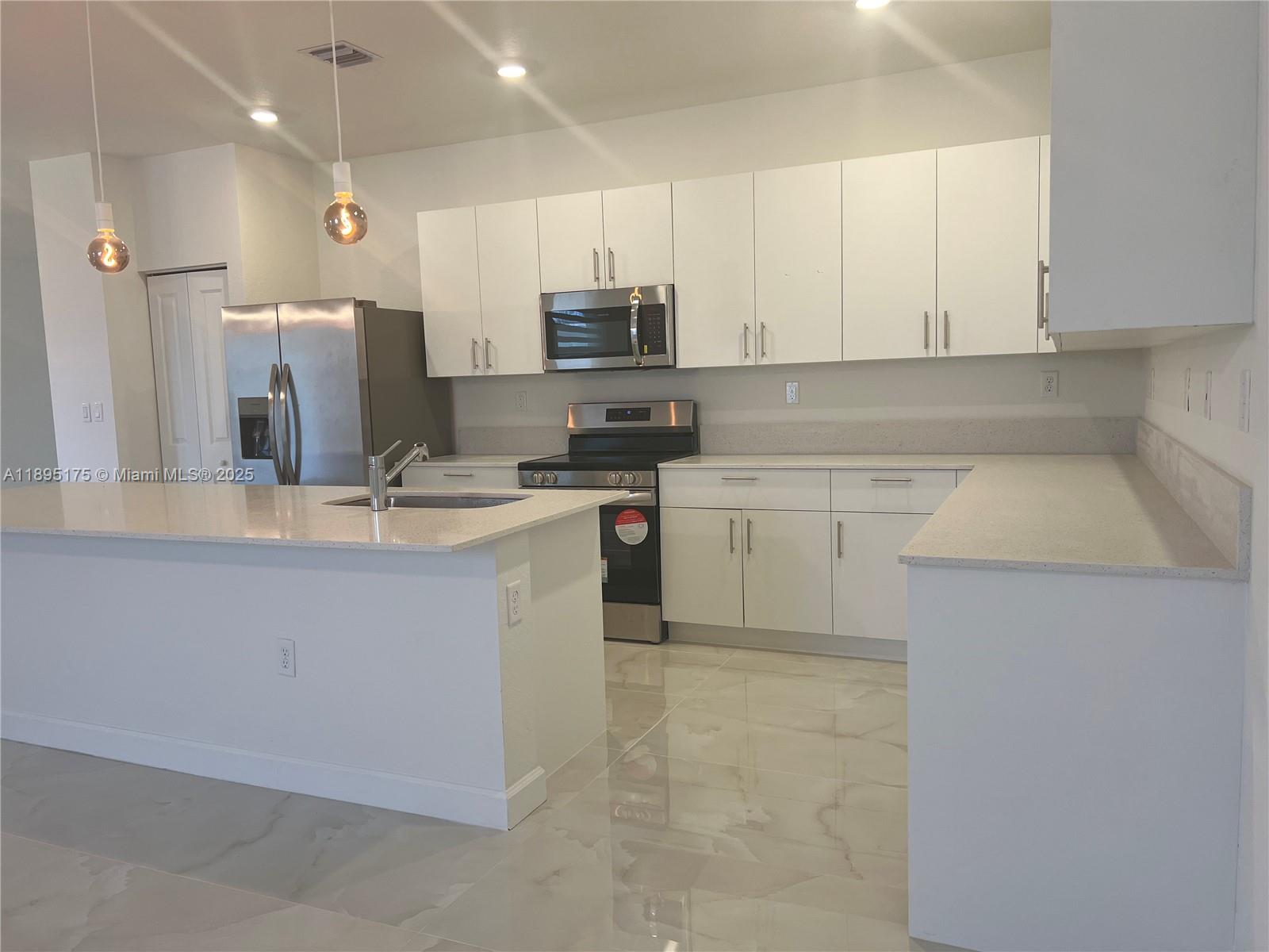16960 Southwest 288th Terrace, Unit 16960 Homestead, FL 33033 - Photo 2 of 33 a kitchen with stainless steel appliances granite countertop a sink stove and refrigerator
