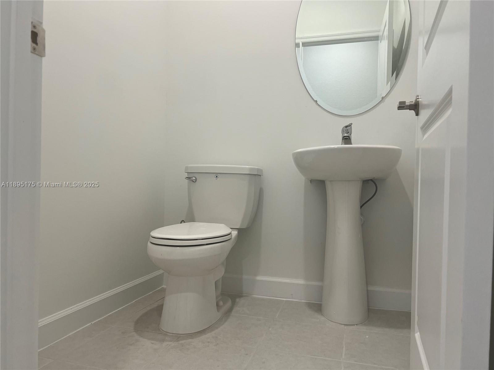 16960 Southwest 288th Terrace, Unit 16960 Homestead, FL 33033 - Photo 25 of 33 a bathroom with a toilet sink and mirror