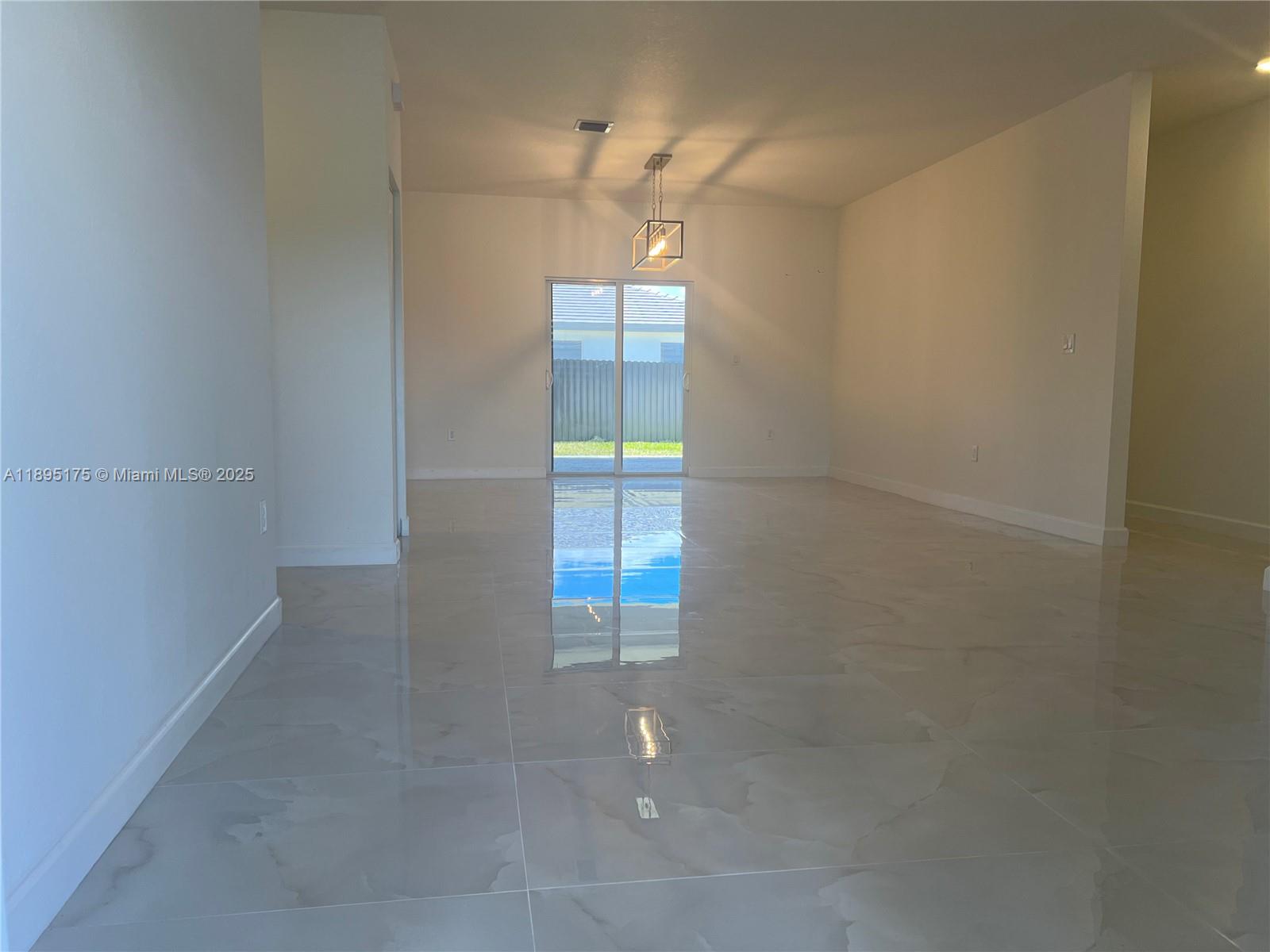16960 Southwest 288th Terrace, Unit 16960 Homestead, FL 33033 - Photo 6 of 33 en empty room with windows and fan