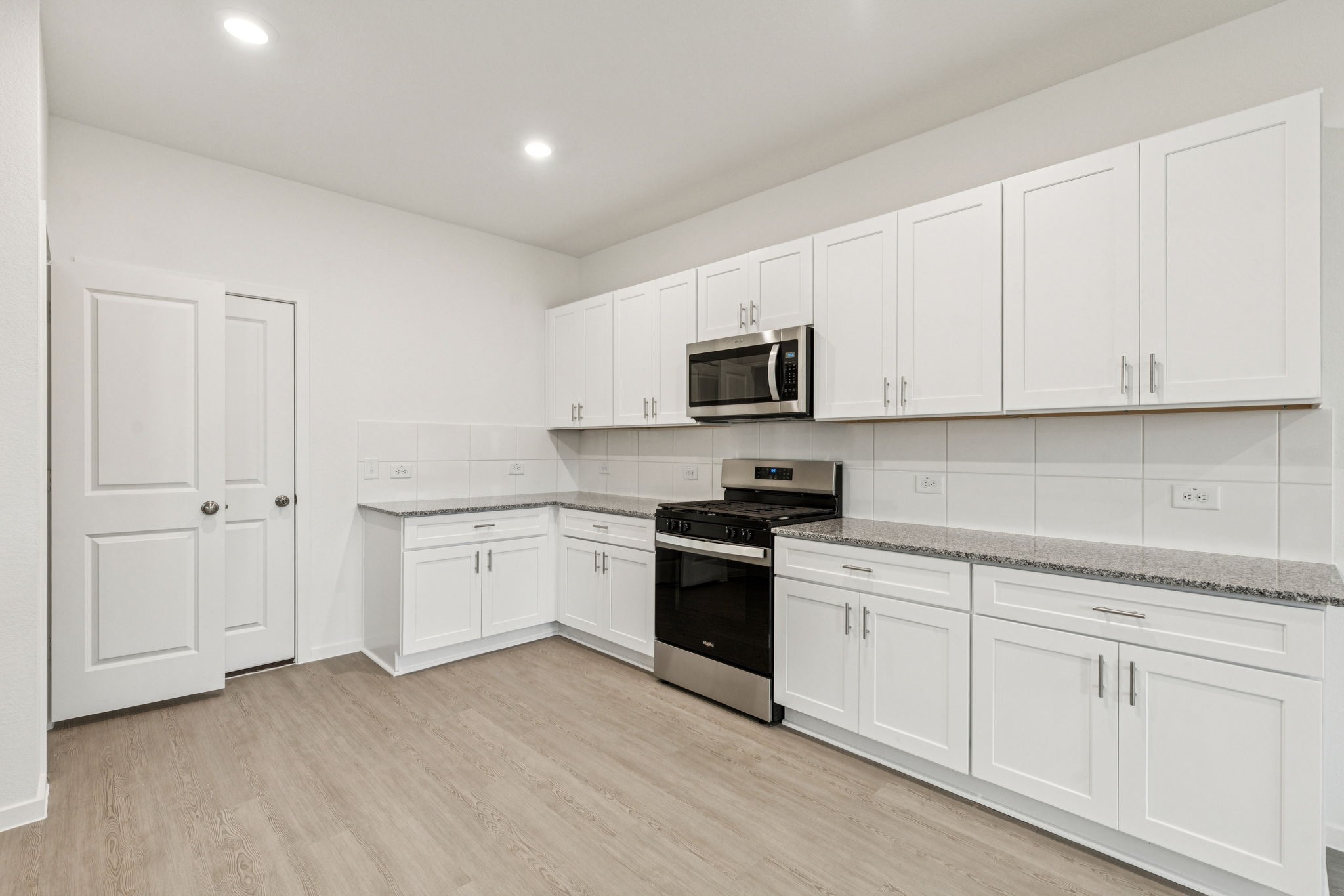 16148 Sepia Manor Street Conroe, TX 77302 - Photo 11 of 32 a kitchen with granite countertop white cabinets and stainless steel appliances