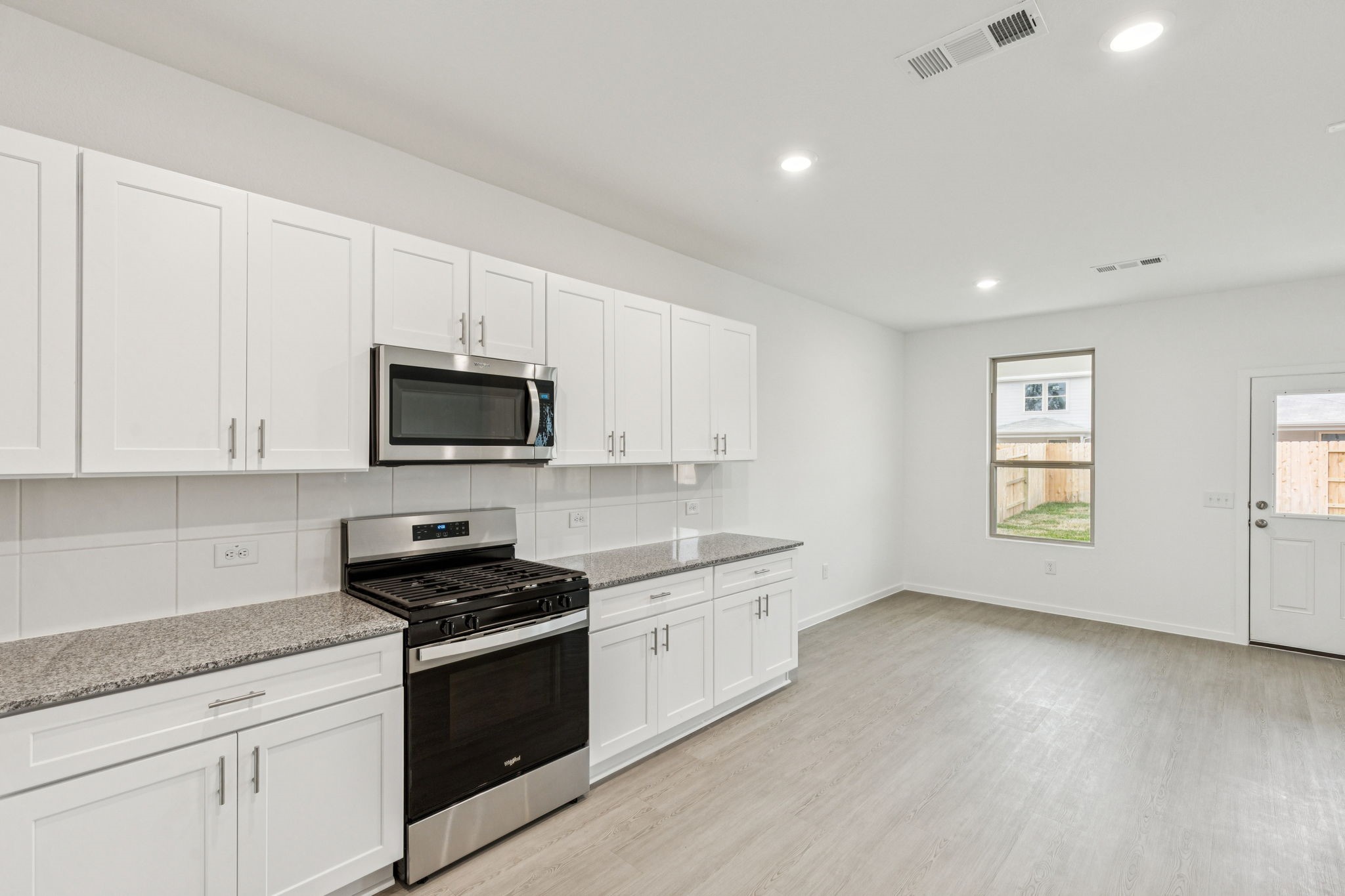 16148 Sepia Manor Street Conroe, TX 77302 - Photo 14 of 32 a kitchen with granite countertop white cabinets and black appliances