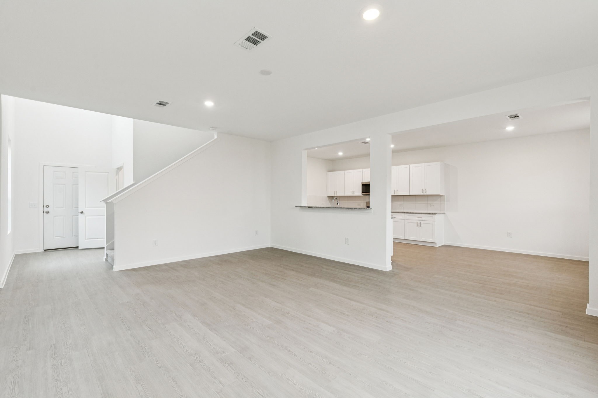 16148 Sepia Manor Street Conroe, TX 77302 - Photo 8 of 32 wooden floor in an empty room with a kitchen
