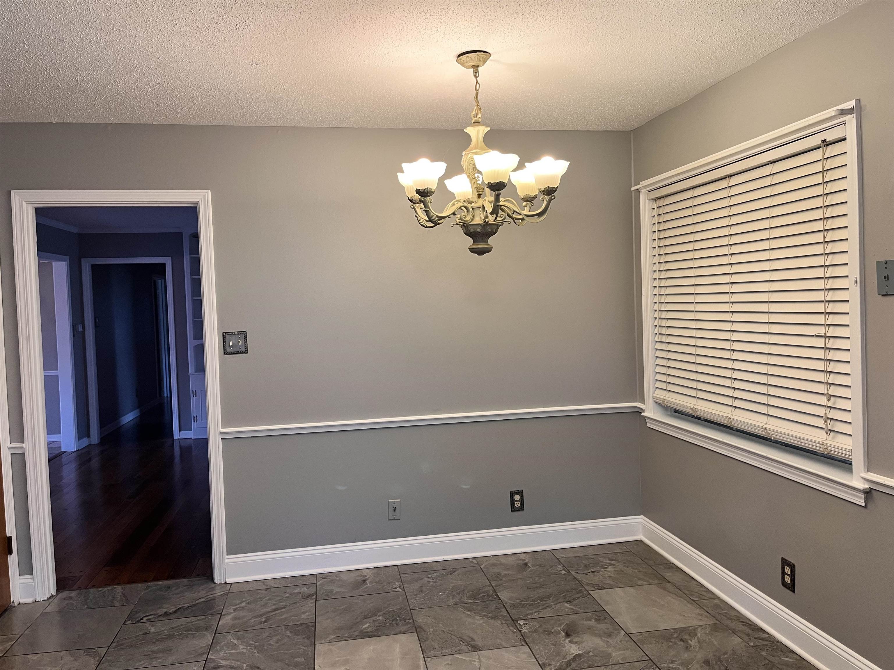 4282 Millbranch Road Memphis, TN 38116 - Photo 12 of 28 Unfurnished room with a chandelier and a textured ceiling