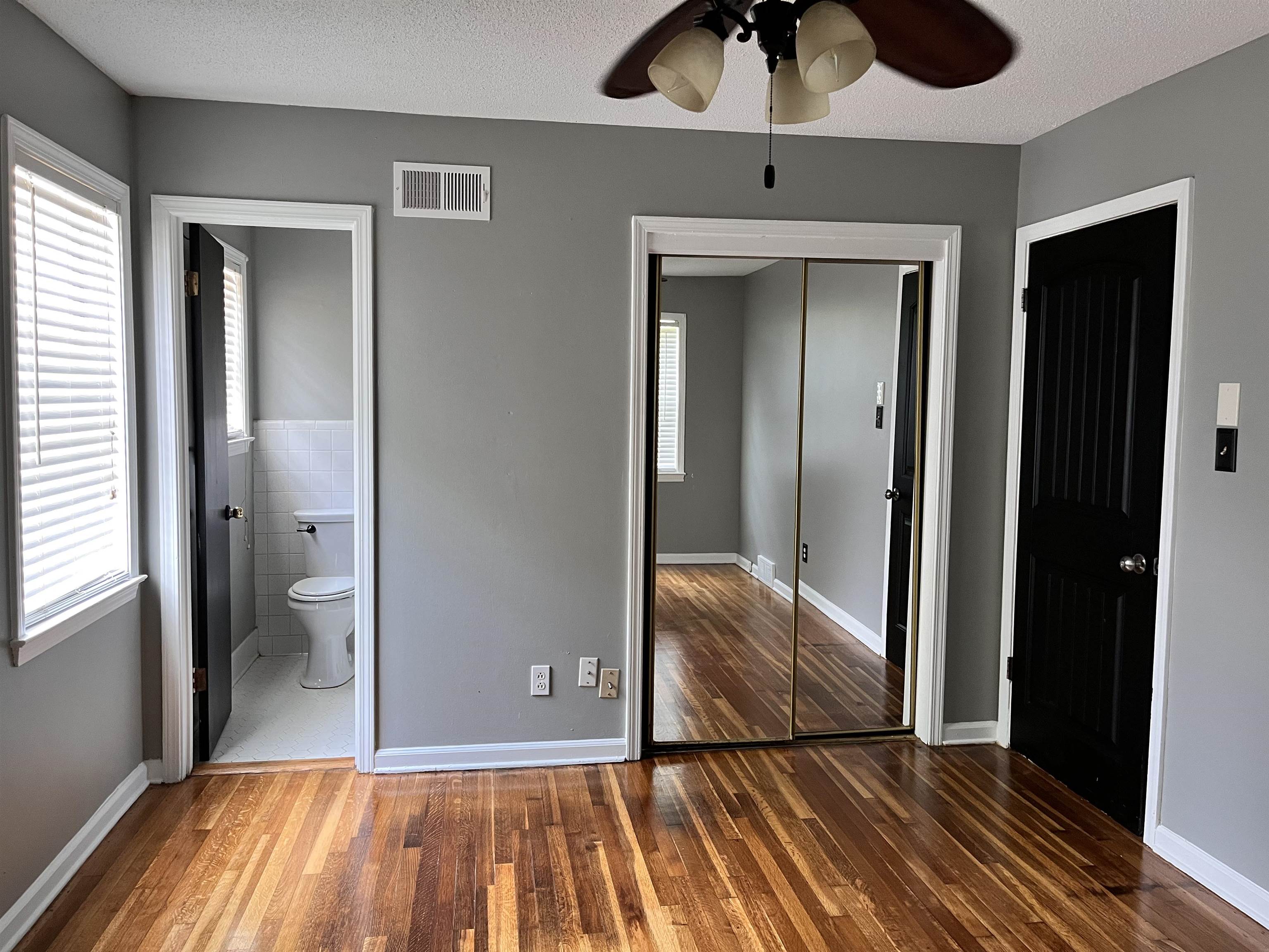4282 Millbranch Road Memphis, TN 38116 - Photo 15 of 28 Unfurnished bedroom with wood finished floors, a closet, connected bathroom, and ceiling fan