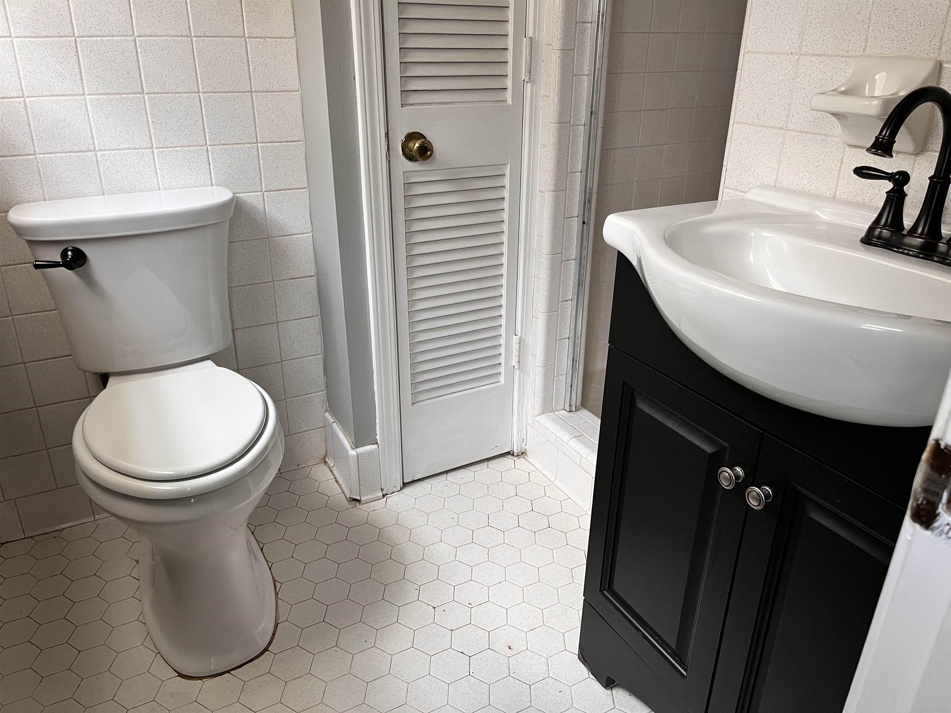 4282 Millbranch Road Memphis, TN 38116 - Photo 17 of 28 Bathroom with tile walls, tile patterned flooring, and vanity