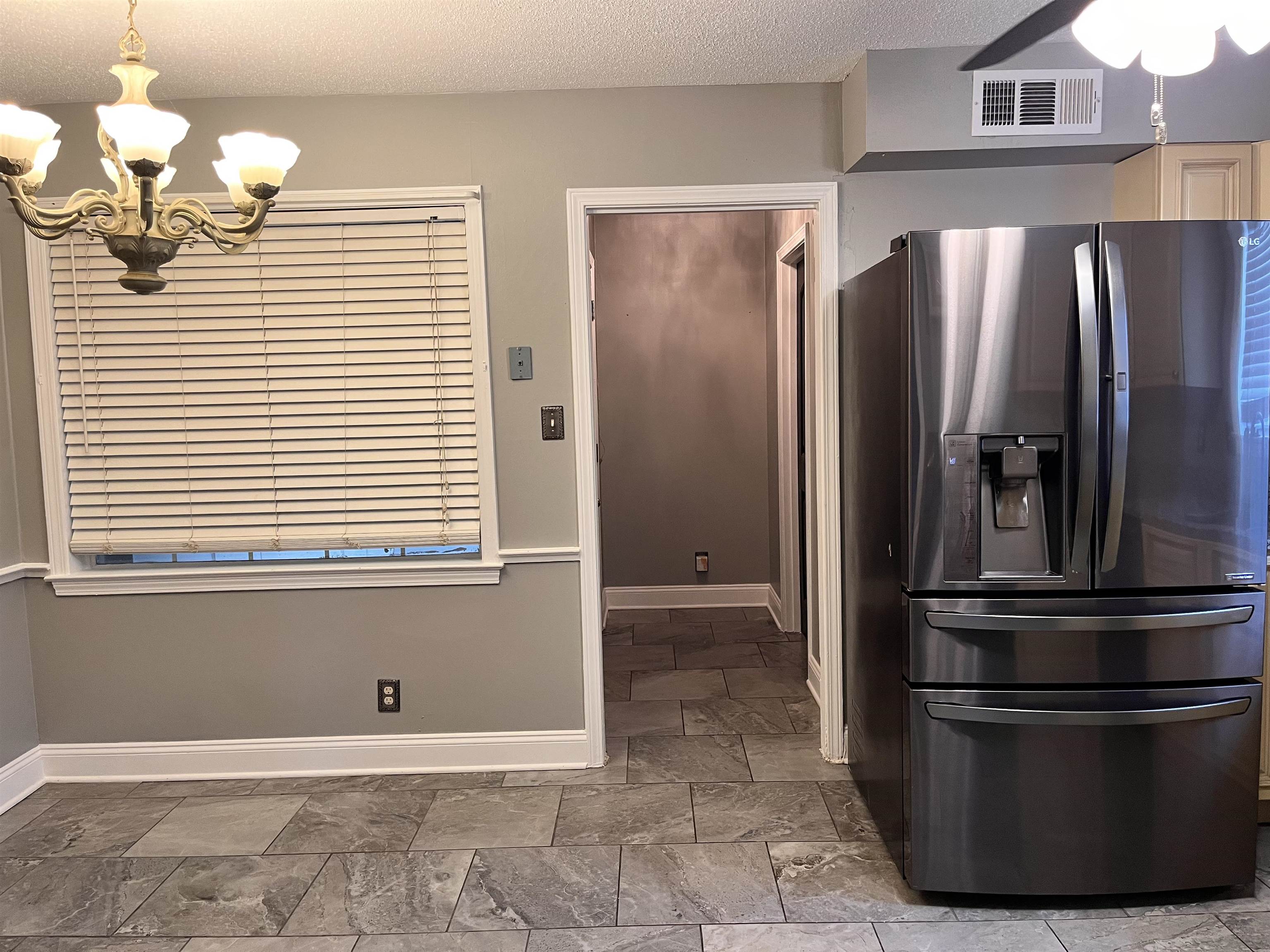 4282 Millbranch Road Memphis, TN 38116 - Photo 8 of 28 Kitchen with stainless steel refrigerator with ice dispenser, a chandelier, a textured ceiling, ceiling fan, and pendant lighting