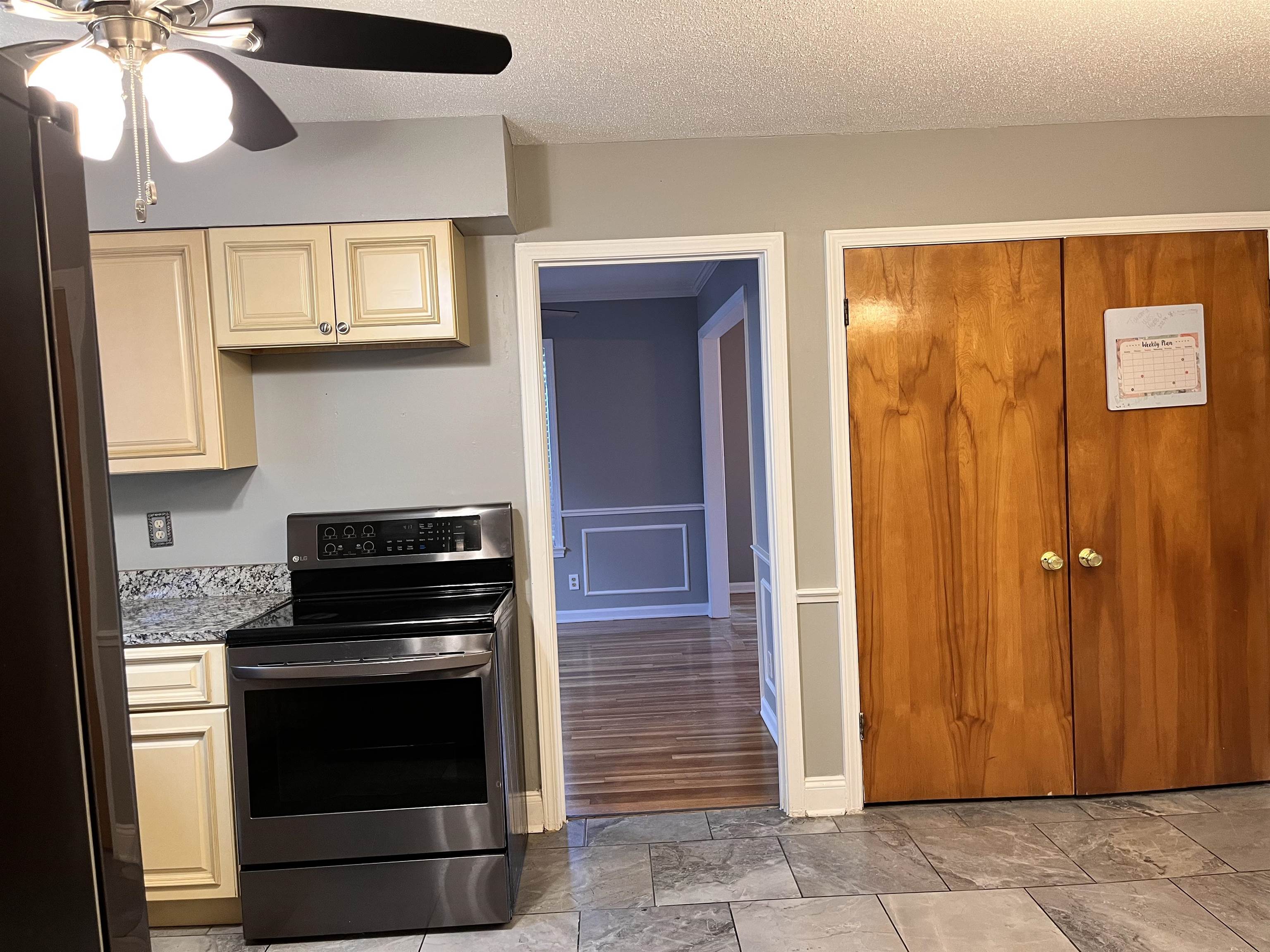 4282 Millbranch Road Memphis, TN 38116 - Photo 10 of 28 Kitchen featuring stainless steel appliances, cream cabinetry, a ceiling fan, and a textured ceiling