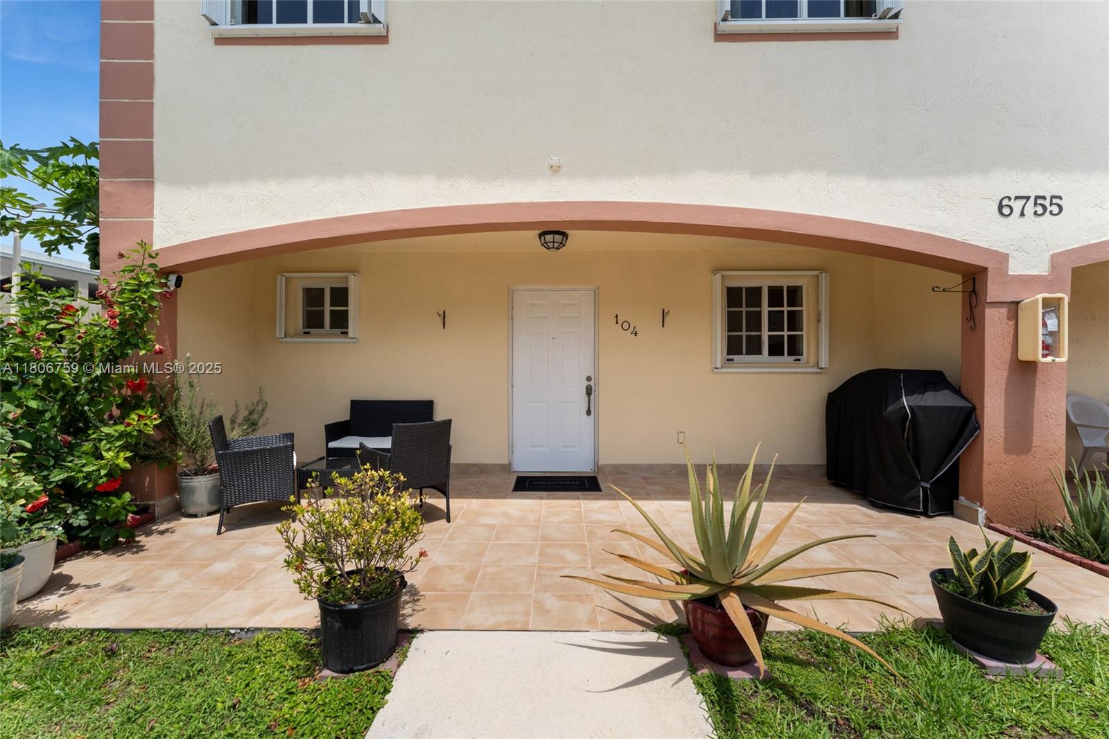 6755 Northwest 182nd Street, Unit 104 Hialeah, FL 33015 - Photo 1 of 33 a front view of a house with outdoor seating and plants