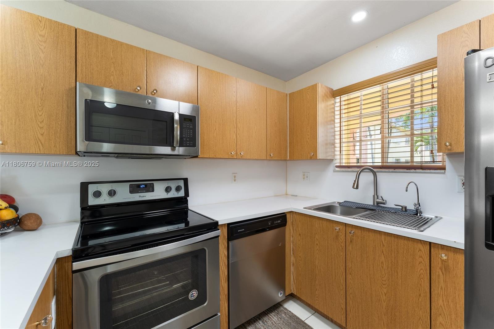 6755 Northwest 182nd Street, Unit 104 Hialeah, FL 33015 - Photo 17 of 33 a kitchen with a sink stove and microwave