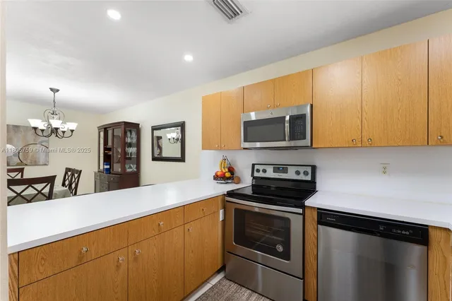 a kitchen with stainless steel appliances a stove a microwave a sink and cabinets