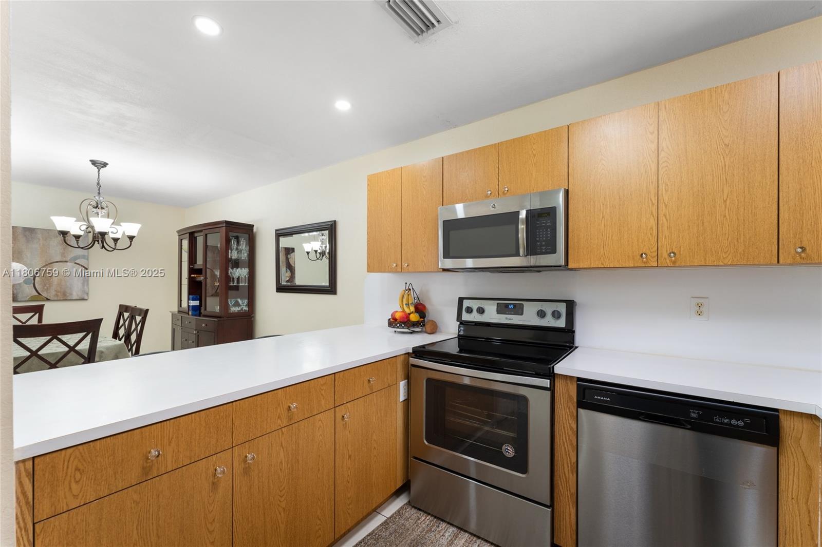 6755 Northwest 182nd Street, Unit 104 Hialeah, FL 33015 - Photo 18 of 33 a kitchen with stainless steel appliances a stove a microwave a sink and cabinets