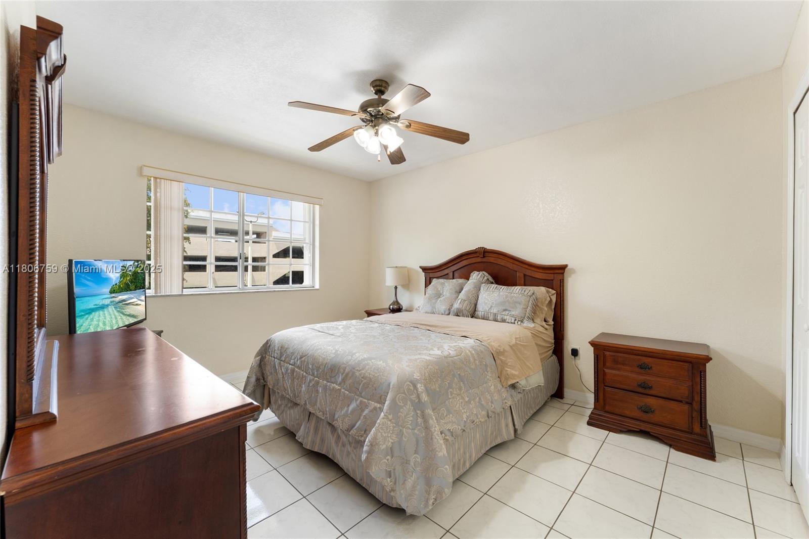 6755 Northwest 182nd Street, Unit 104 Hialeah, FL 33015 - Photo 21 of 33 a bedroom with a bed and a chandelier