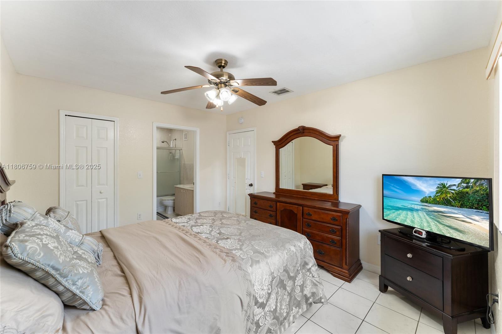 6755 Northwest 182nd Street, Unit 104 Hialeah, FL 33015 - Photo 22 of 33 a bedroom with a bed and a flat screen tv