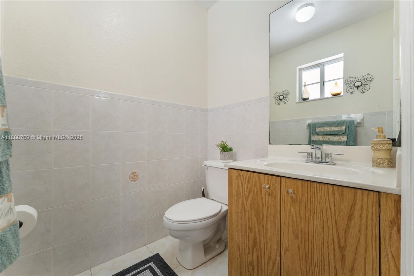 6755 Northwest 182nd Street, Unit 104 Hialeah, FL 33015 - Photo 26 of 33 a bathroom with a sink a toilet and mirror