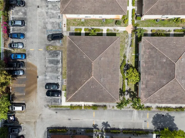 an aerial view of a house with a yard and a large tree