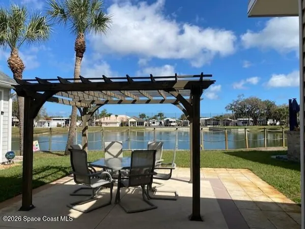 a view of a swimming pool with a table and chairs under an umbrella