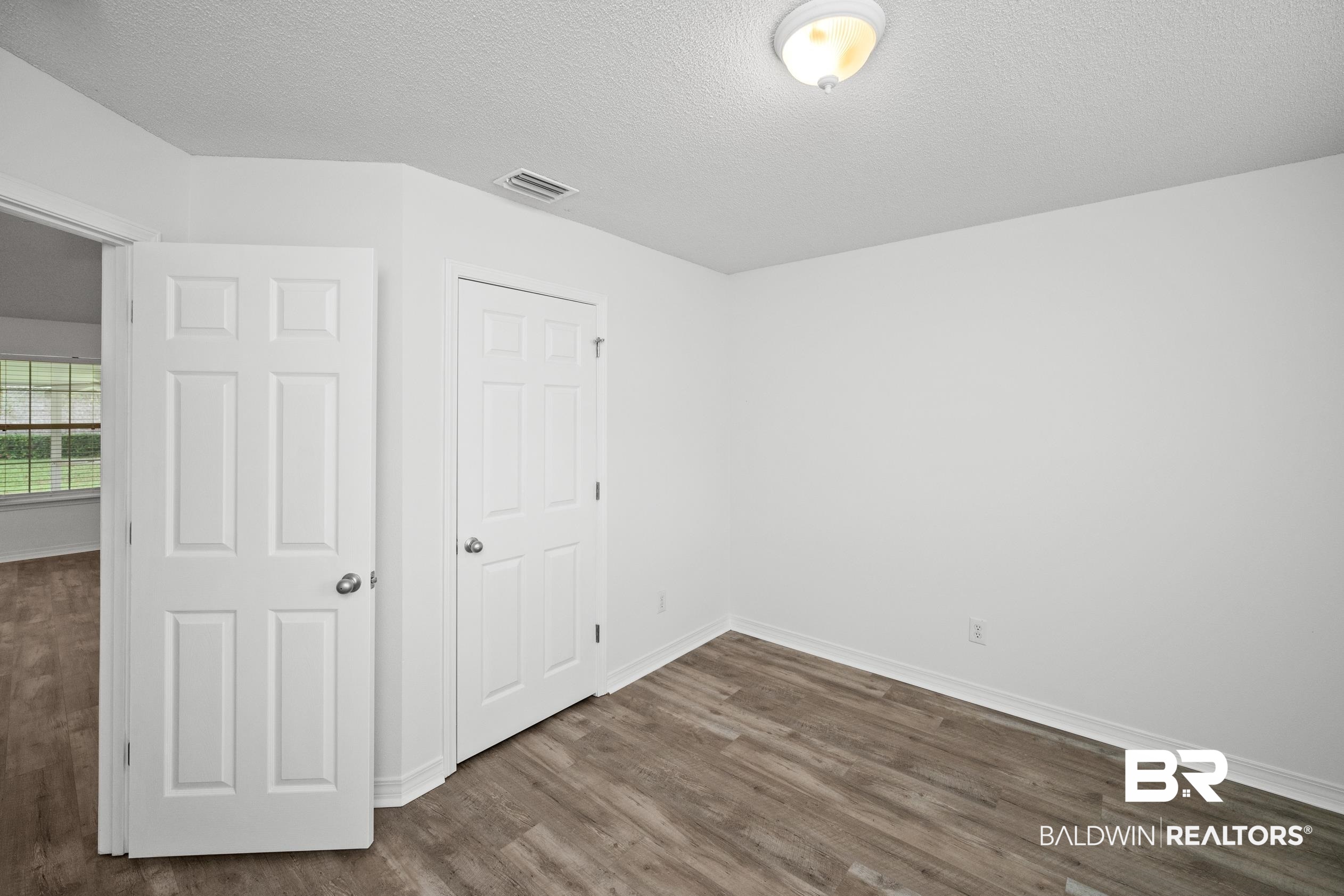 306 Monteith Oaks Drive Foley, AL 36535 - Photo 24 of 38 Unfurnished bedroom with a textured ceiling, dark wood-style floors, and a closet