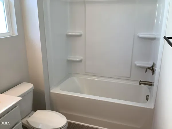 a white bath tub sitting next to a white toilet