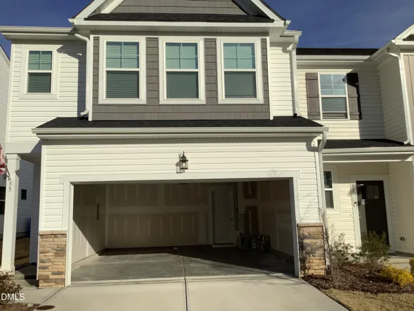 a front view of a house with plants