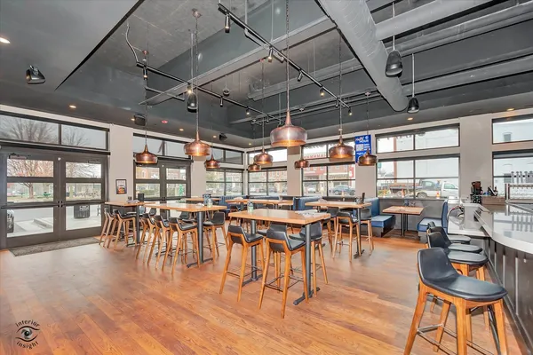a dining hall with lots of furniture and wooden floor