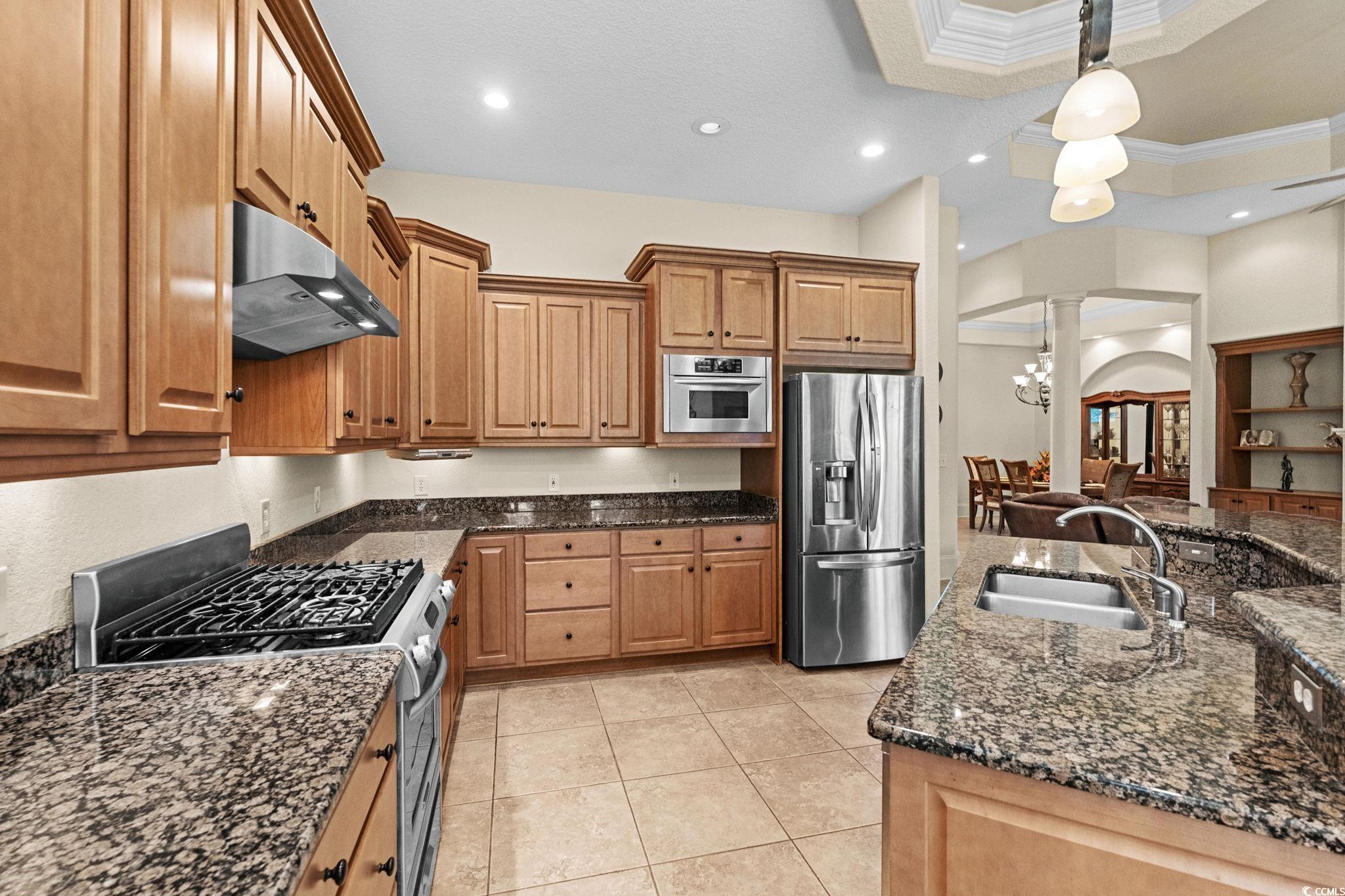 9891 Bellasera Circle Myrtle Beach, SC 29579 - Photo 13 of 40 Kitchen with appliances with stainless steel finishes, a chandelier, dark stone countertops, recessed lighting, and hanging light fixtures