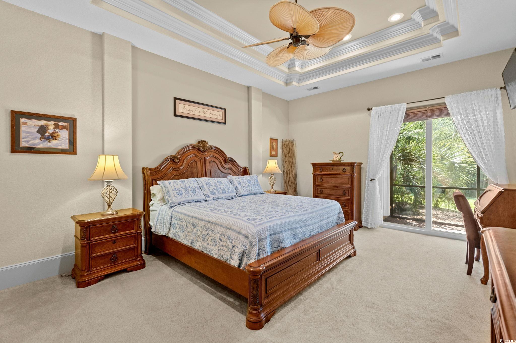 9891 Bellasera Circle Myrtle Beach, SC 29579 - Photo 21 of 40 Carpeted bedroom featuring a tray ceiling, access to outside, ornamental molding, and ceiling fan