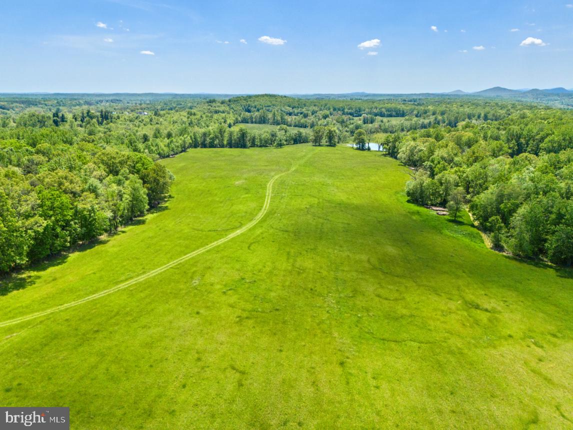 a view of a big green field with an ocean view