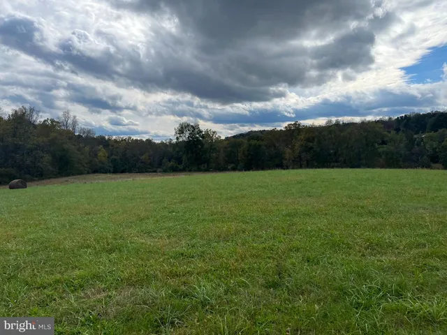 a view of a green field with wooden fence