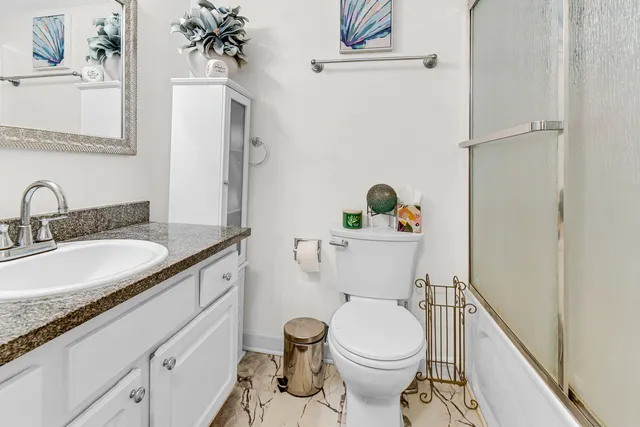 a view of a hallway with a chair and a livingroom with furniture