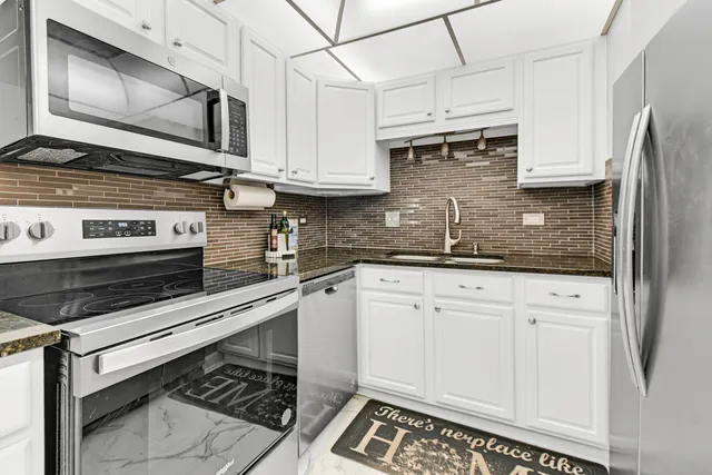 a kitchen with stainless steel appliances granite countertop a refrigerator and a sink