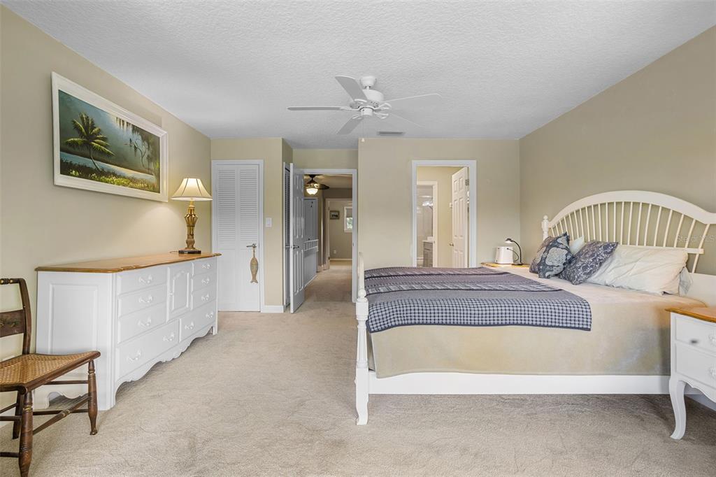 2329 River Ridge Road, Unit 15 DeLand, FL 32720 - Photo 19 of 40 a spacious bedroom with a bed a lamp and a chandelier