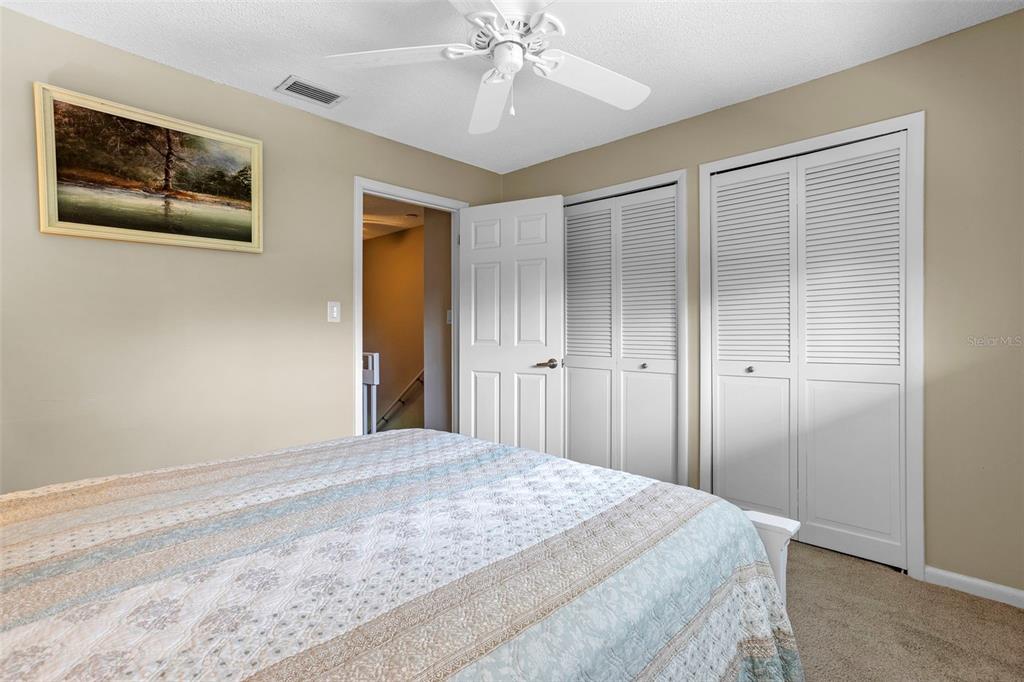 2329 River Ridge Road, Unit 15 DeLand, FL 32720 - Photo 21 of 40 a bedroom with a bed and a chandelier
