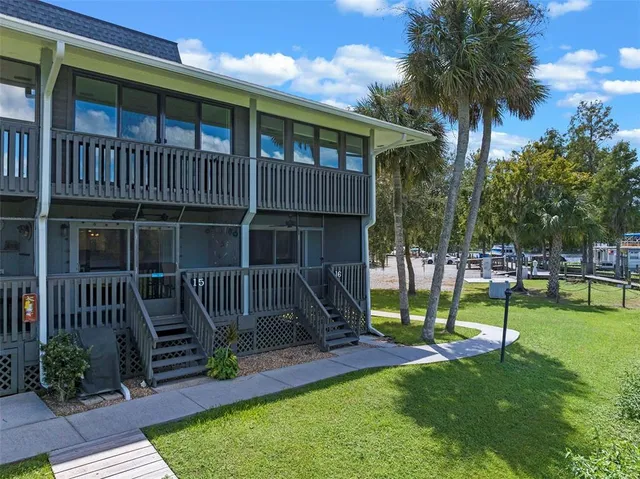 a view of house with a big yard and potted plants