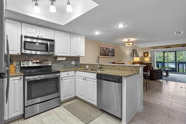 a kitchen with granite countertop stainless steel appliances a stove sink and microwave