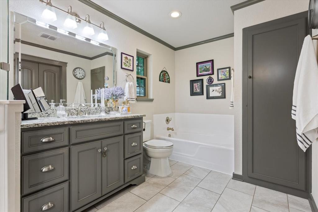 649 Wedgewood Drive China Spring, TX 76633 - Photo 16 of 39 Full bathroom featuring ornamental molding, vanity, a garden tub, and light tile patterned floors