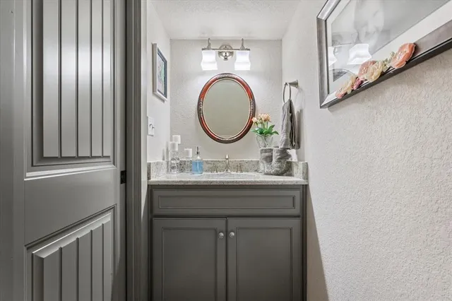 a bathroom with a granite countertop sink a mirror and a shower curtain