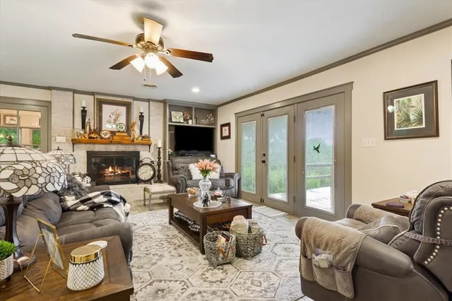a living room with furniture fireplace and a large window