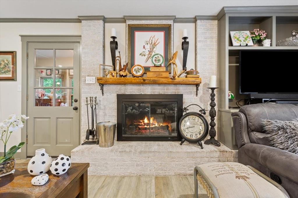 649 Wedgewood Drive China Spring, TX 76633 - Photo 4 of 39 Living area featuring a fireplace, wood finished floors, and crown molding