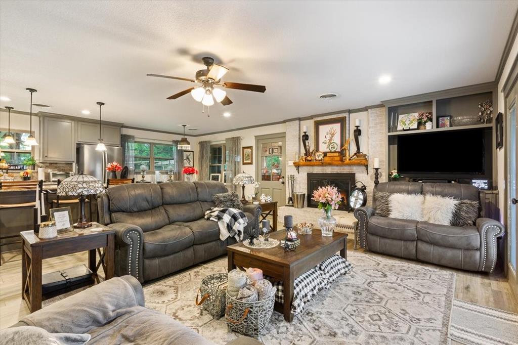 649 Wedgewood Drive China Spring, TX 76633 - Photo 5 of 39 Living room featuring wood finished floors, a fireplace, ornamental molding, ceiling fan, and recessed lighting