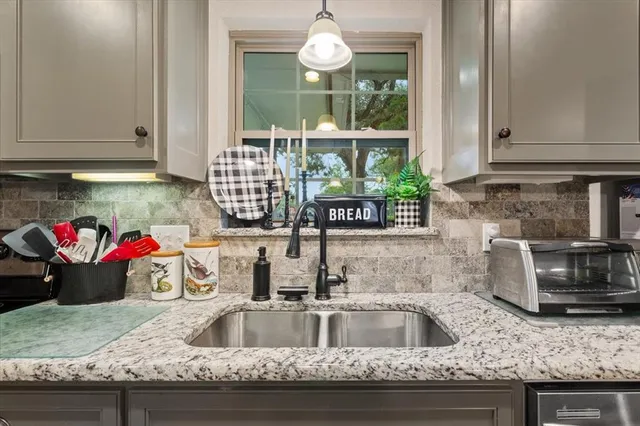 a kitchen with granite countertop a sink and a window