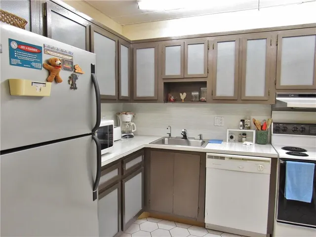 a kitchen with a sink a refrigerator and cabinets