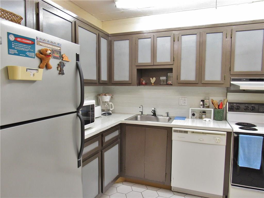 2661 South Course Drive, Unit 404 Pompano Beach, FL 33069 - Photo 12 of 16 a kitchen with a sink a refrigerator and cabinets